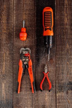Flat lay view of various red tools on a wooden surface, perfect for DIY and workshop themes.